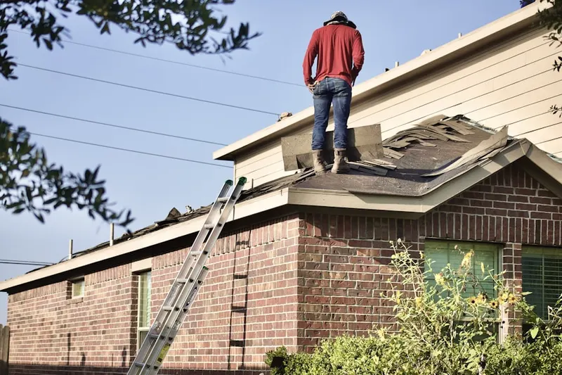 Professional roofer working on a residential roof in Del Prado Bolsa